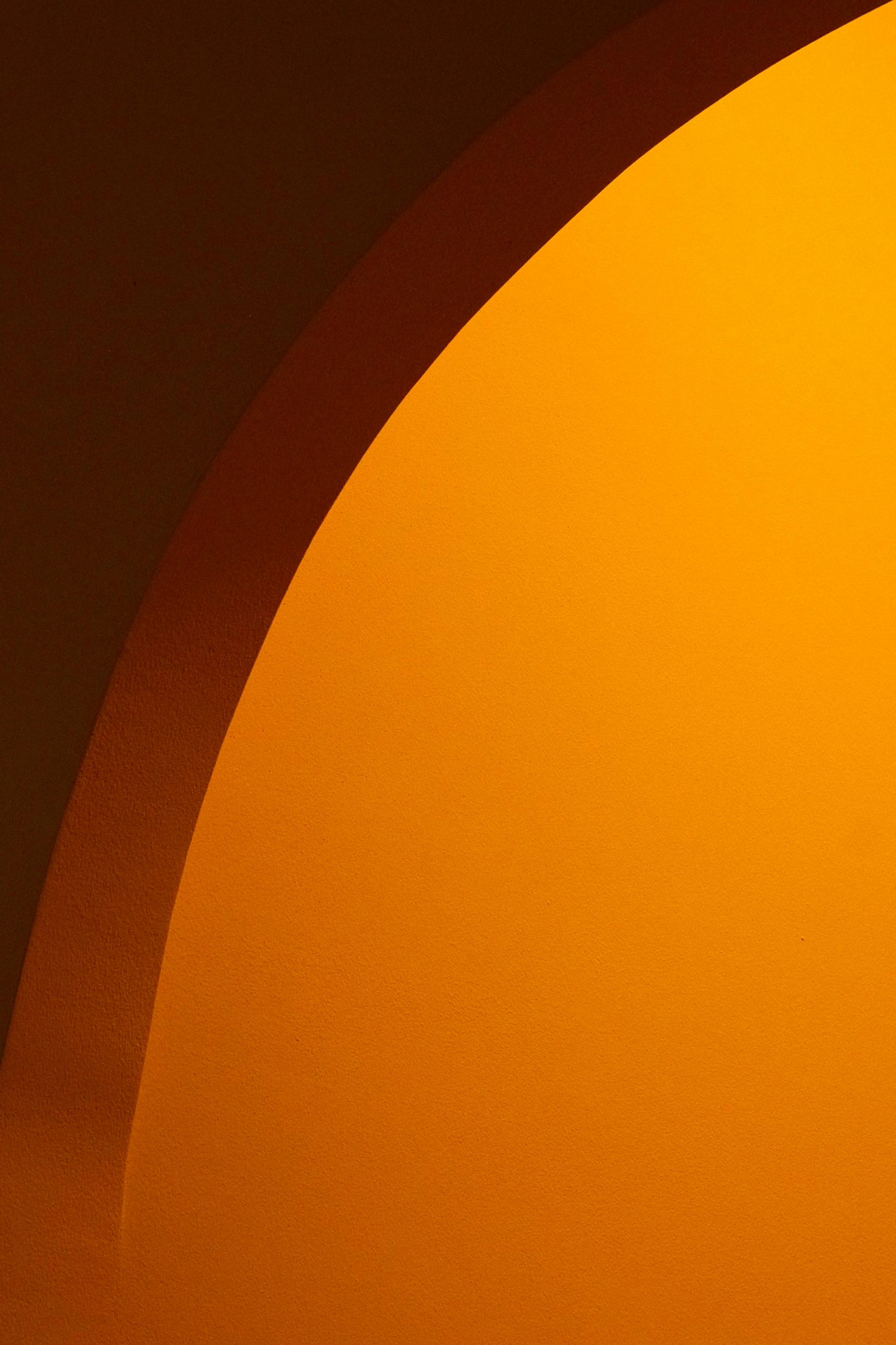 Abstract image showcasing a warm shadow on an orange background, creating a minimalist and artistic effect.